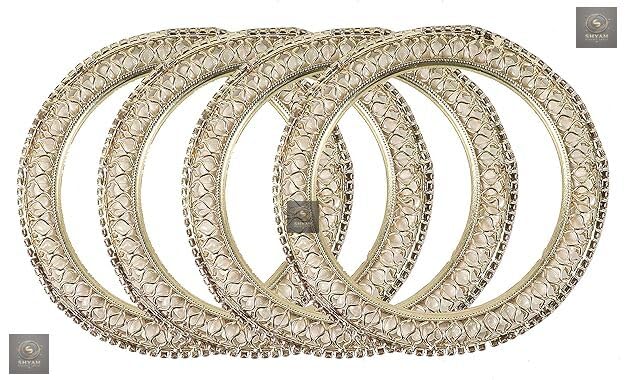 Golden kada set with artificial pearls and zircon gemstones in an intricate curved pattern.