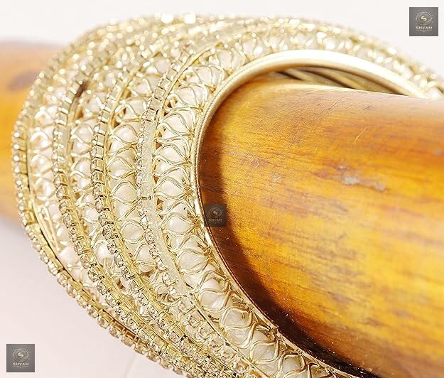 Golden kada set with artificial pearls and zircon gemstones in an intricate curved pattern.